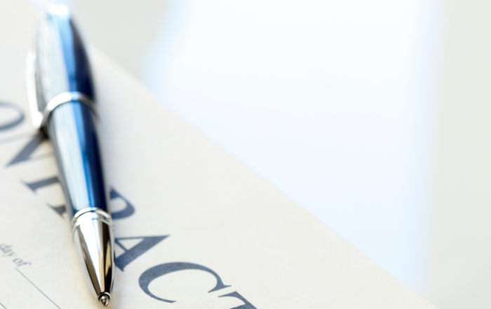 Photograph of a pen laying across an employment contract