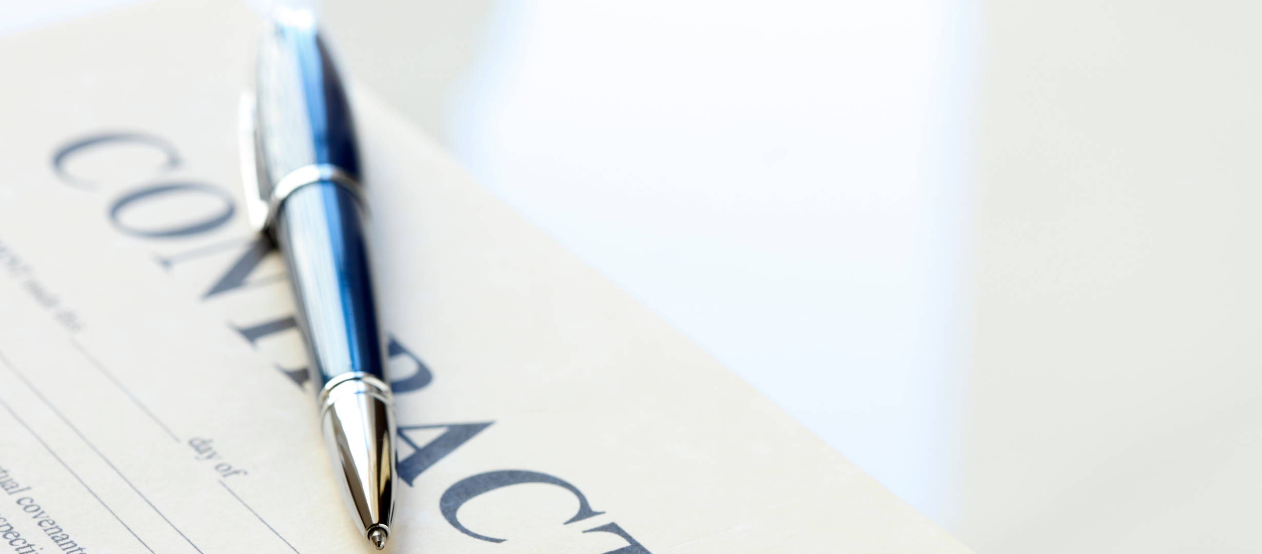Photograph of a pen laying across an employment contract